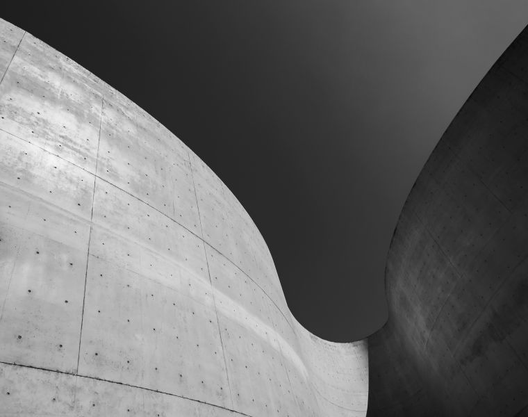 Black and white image of curved concrete architecture against a dark sky-Neutrinos