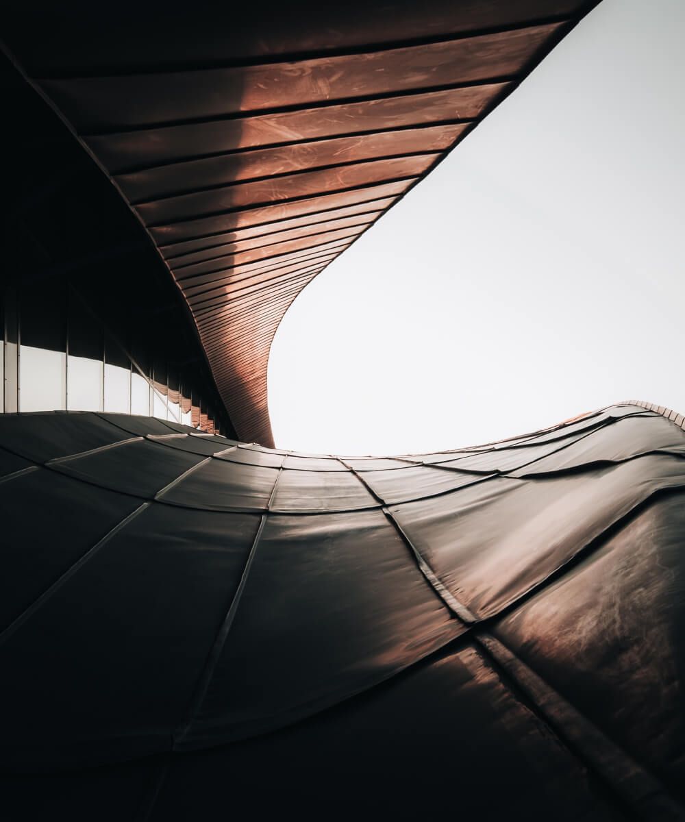 Curved modern architectural structure with metal panels and soft lighting- Neutrinos